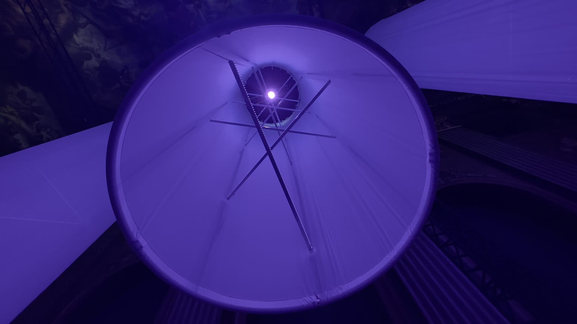 Colonne lumineuse cylindrique dans le Painted Hall, vue d’en bas, baignée de violet profond